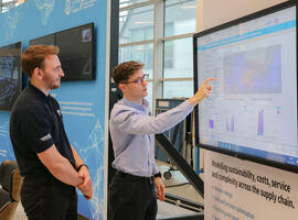 Two engineers review a digital dashboard