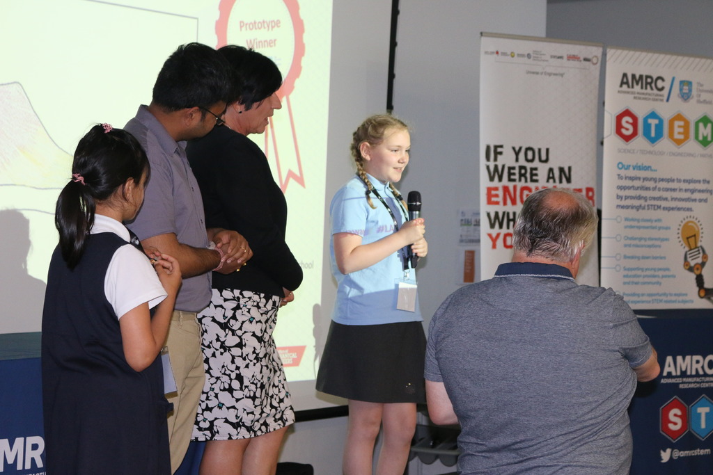 Prototype winners Zahra Ali and Sophie Alice Tapper on stage with Dr Rahul Mandal, STEM Ambassador for the AMRC, and Cathie Barker from the STEM and Outreach Team at the AMRC.