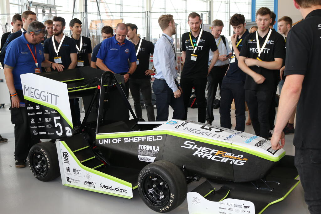 Gareth Wilkinson from the AMRC Training Centre (left in blue) inspects the car during the unveiling at Factory 2050. 