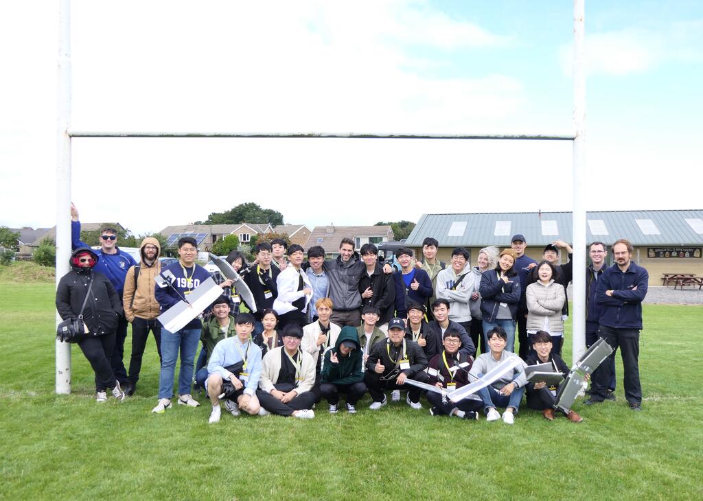 The twenty-six students who took part in the International Industrial Demonstration Programme (IIDP) pose for a picture with AMRC engineers at Stocksbridge Rugby Club.