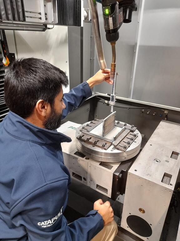 Muhammad Shamir, technical lead within the AM team at AMRC North West, measuring height of the wire arc additive manufactured (WAAM) wall to control layer height and process parameters. 